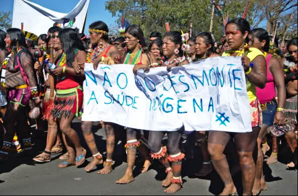 Mujeres indígenas de brasil protestan contra la destrucción de sus territorios con una pancarta en la que dice “Nao ao desmonte” contra la deforestación de la selva tropical
