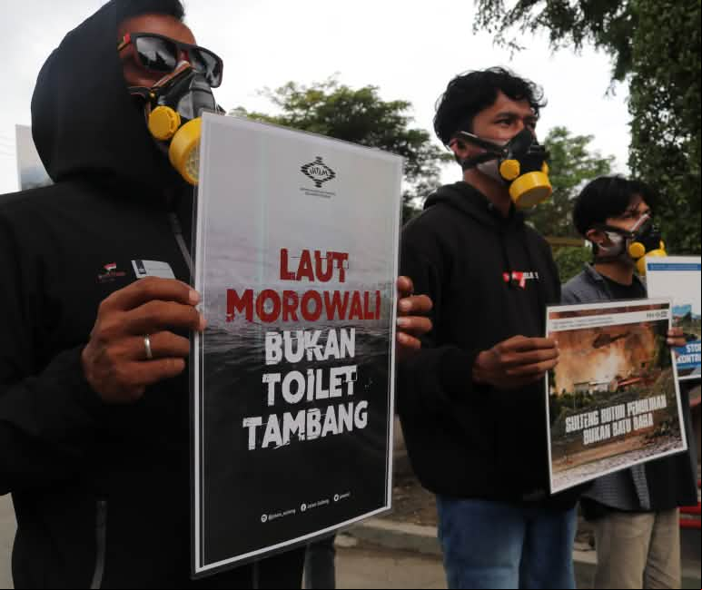 La pancarta dice: "El mar de Morowali no es un retrete para la minería" Tres activistas de Jatam con pancartas de protesta en las que se lee en indonesio "El mar de Morowali no es un retrete para la minería"